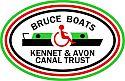 Bruce Boats (Kennet and Avon Canal Trust) Logo. The words "Bruce Boats" arched over a drawing of a canal boat with a wheelchair icon in the centre and Kennet and Avon Canal Trust in two straight lines underneath. All in an oval, with three thin lines surrounding - green on the outside, then red and black inside.