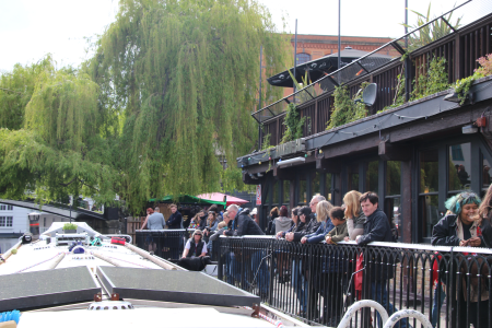Towpath Safety: Photograph from a boat going up in Camden Lock, with gongoozlers watching from the lock side behind a safety barrier.
