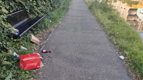 Towpath with litter strewn by a seat